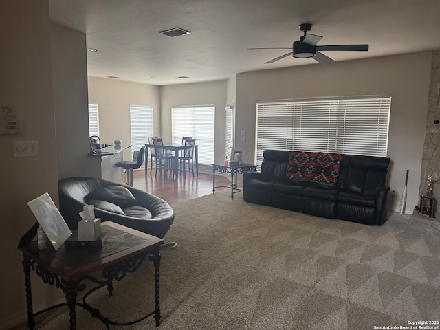 carpeted living room featuring a ceiling fan