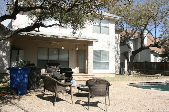 rear view of property featuring fence, a patio, a fenced in pool, ceiling fan, and stucco siding