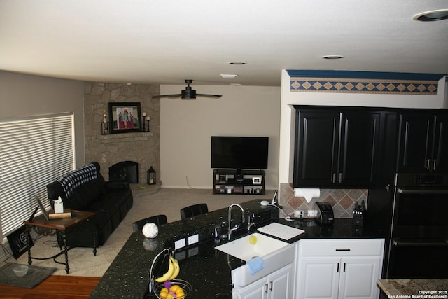 kitchen featuring a ceiling fan, a sink, dobule oven black, and open floor plan