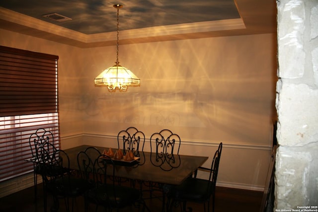 dining area featuring a raised ceiling, visible vents, baseboards, an inviting chandelier, and ornamental molding