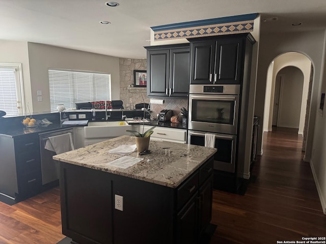 1530 Pheasant Rdg, San Antonio, TX 78248 - kitchen featuring light stone countertops, a sink, dark wood-type flooring, a kitchen island, and appliances with stainless steel finishes