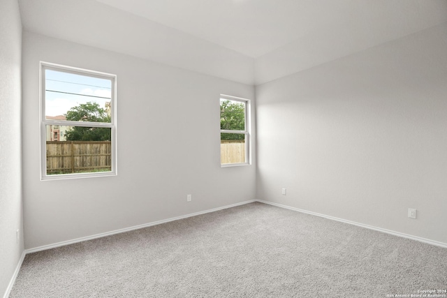 carpeted empty room featuring baseboards