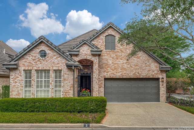 traditional home featuring a tile roof, concrete driveway, and brick siding