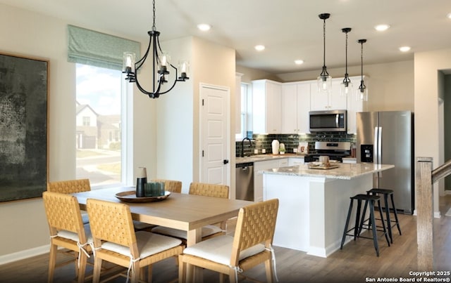 dining area featuring recessed lighting, a notable chandelier, dark wood finished floors, and baseboards