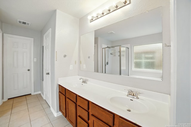 bathroom featuring a sink, tile patterned flooring, visible vents, and a shower stall