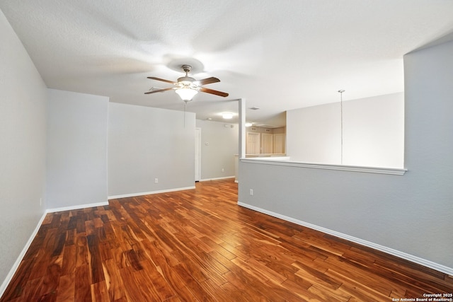 spare room with wood finished floors, ceiling fan, and baseboards