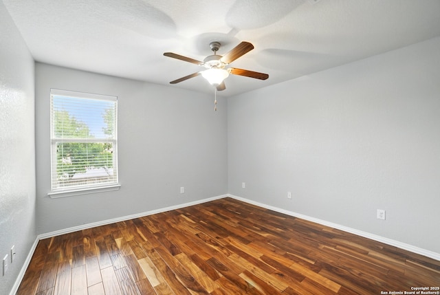 unfurnished room with baseboards, a ceiling fan, and dark wood-style flooring