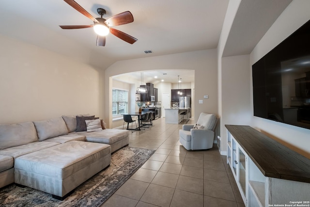 living room with light tile patterned flooring, a ceiling fan, and visible vents
