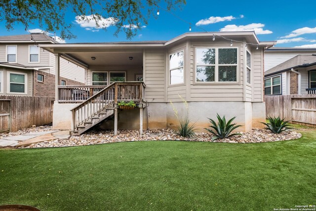 rear view of house with fence, stairway, and a yard
