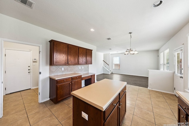 kitchen featuring decorative backsplash, a chandelier, light tile patterned floors, light countertops, and visible vents