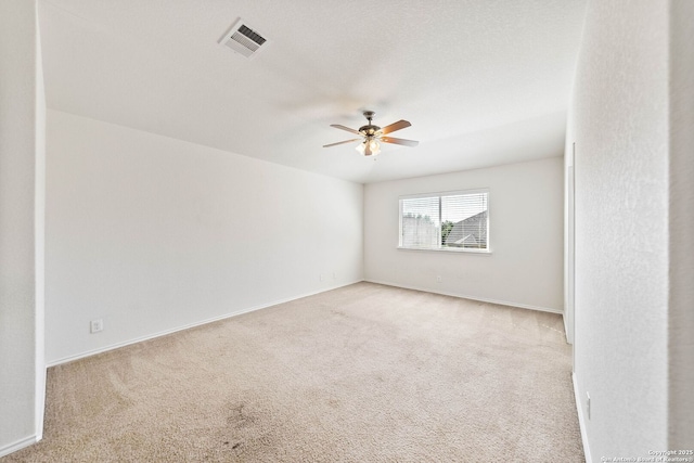 spare room with baseboards, visible vents, a ceiling fan, and carpet floors