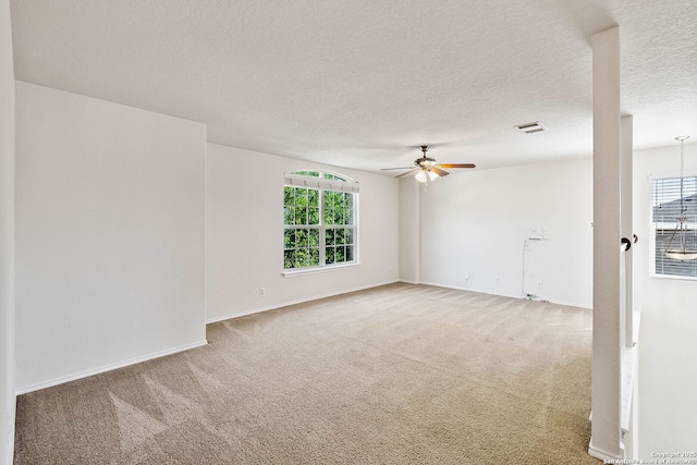 unfurnished room featuring a healthy amount of sunlight, a ceiling fan, and light colored carpet