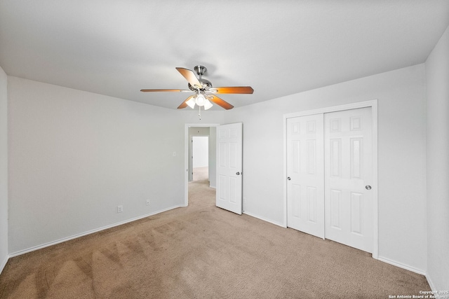 unfurnished bedroom featuring a closet, a ceiling fan, carpet floors, and baseboards