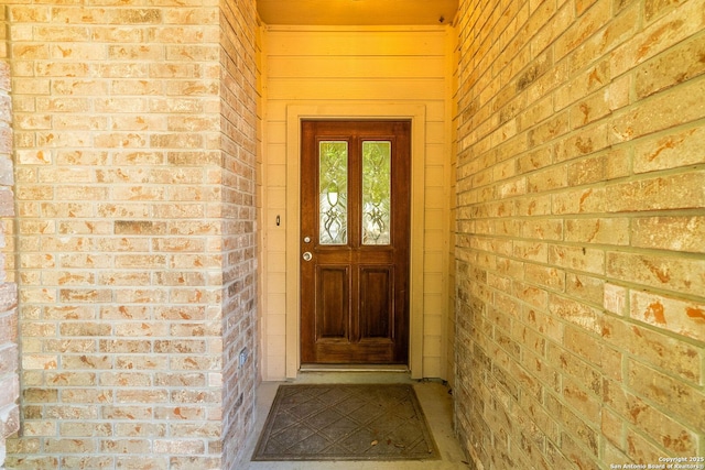 view of exterior entry with brick siding