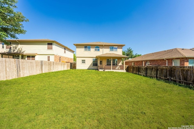 rear view of property featuring a lawn, a patio, and a fenced backyard