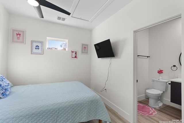 bedroom featuring attic access, light wood finished floors, baseboards, visible vents, and a ceiling fan