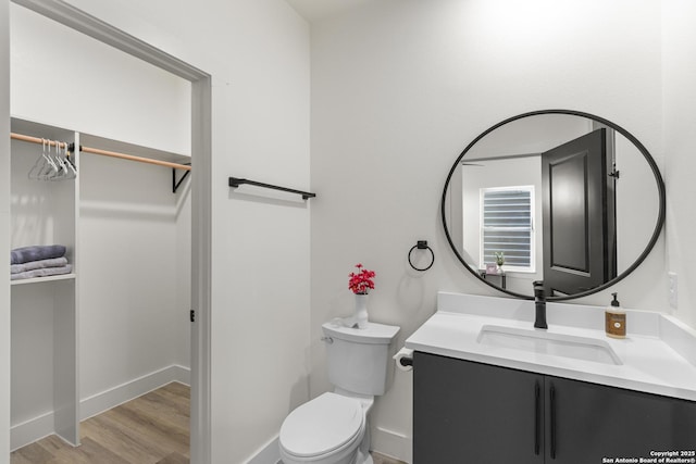 bathroom featuring toilet, wood finished floors, and vanity