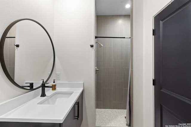 bathroom featuring vanity, recessed lighting, and tiled shower