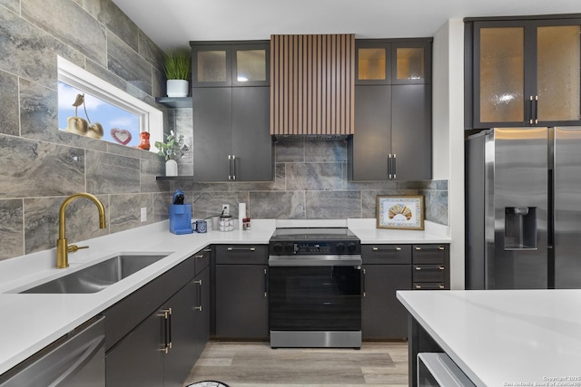 kitchen with stainless steel appliances, extractor fan, light countertops, backsplash, and a sink