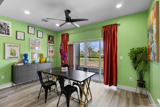 dining room featuring baseboards, visible vents, ceiling fan, and light wood finished floors