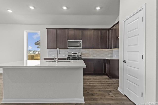 kitchen with stainless steel appliances, dark wood-style floors, dark brown cabinets, decorative backsplash, and recessed lighting