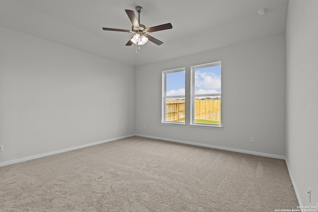 unfurnished room featuring carpet floors, baseboards, and ceiling fan