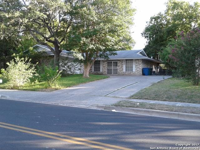 single story home featuring concrete driveway and stone siding