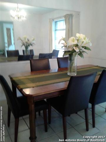 tiled dining room featuring an inviting chandelier