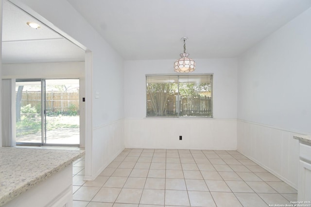 unfurnished dining area featuring wainscoting and light tile patterned flooring