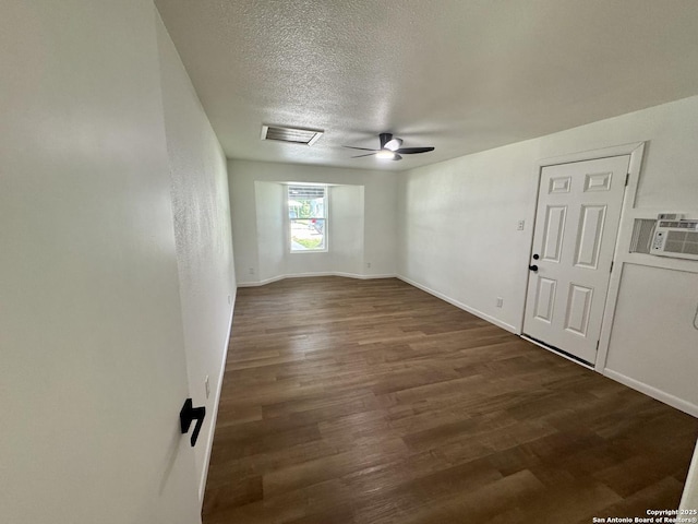 629 Melrose, Seguin, TX 78155 - spare room with baseboards, visible vents, a textured ceiling, and dark wood-type flooring