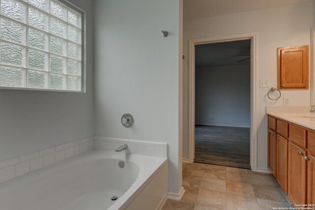 6015 Wexford Pl, San Antonio, TX 78240 - bathroom featuring a garden tub, tile patterned floors, vanity, and baseboards