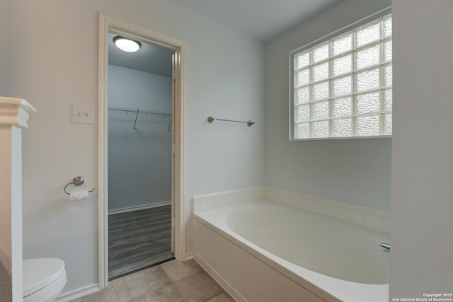 6015 Wexford Pl, San Antonio, TX 78240 - bathroom featuring baseboards, toilet, tile patterned floors, a garden tub, and a spacious closet