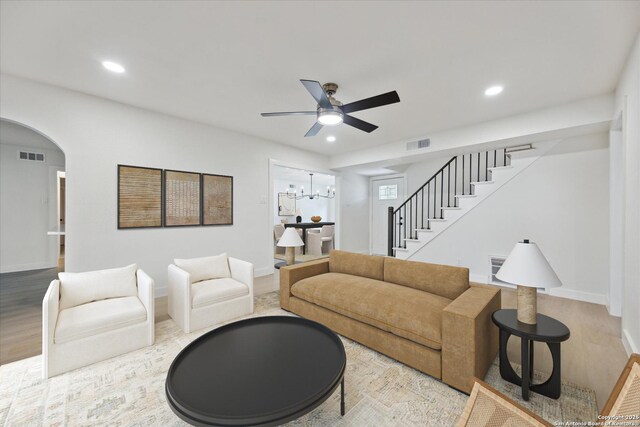 living room featuring visible vents, recessed lighting, stairs, and ceiling fan with notable chandelier