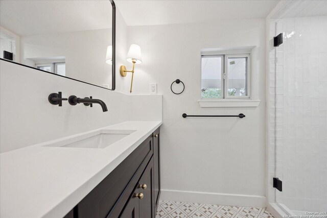 bathroom featuring vanity, tiled shower, and baseboards
