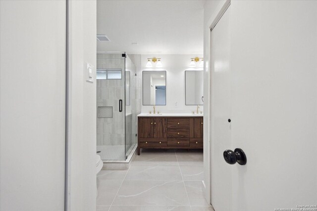 full bathroom featuring a sink, double vanity, a stall shower, toilet, and tile patterned flooring