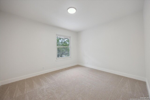 spare room featuring baseboards and carpet floors