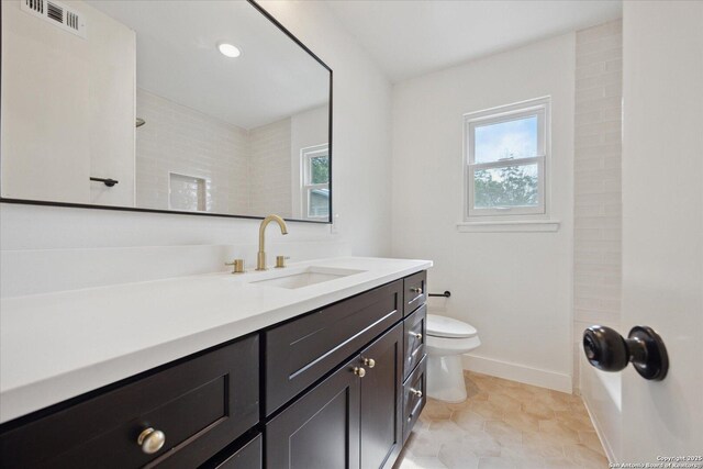 full bath with visible vents, toilet, plenty of natural light, and baseboards