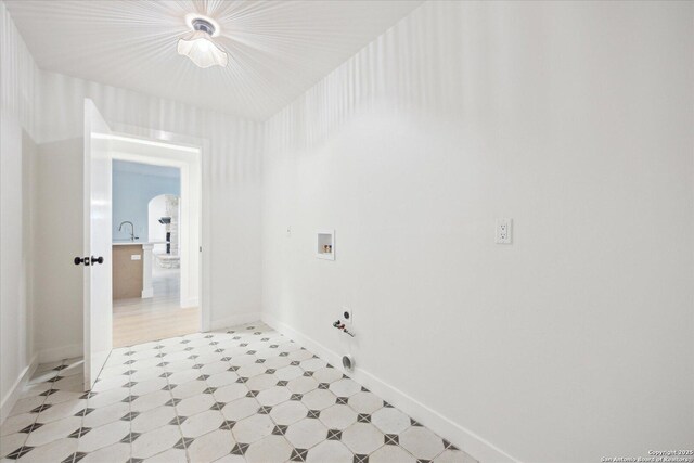 washroom with light floors, washer hookup, baseboards, and arched walkways