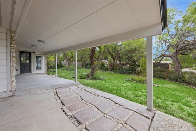 view of patio featuring an attached carport and fence