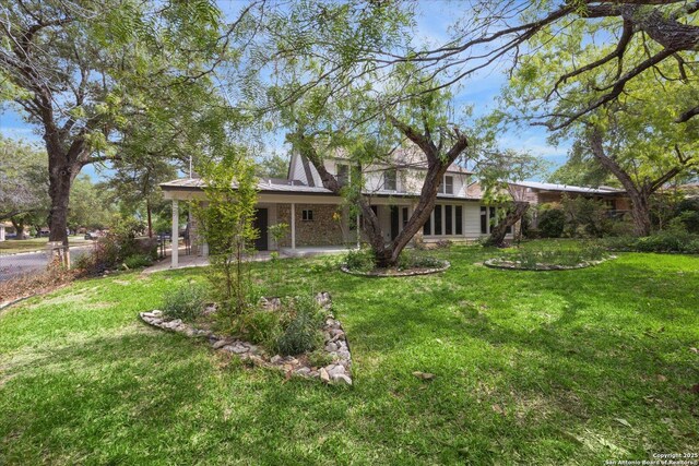 rear view of house featuring a yard