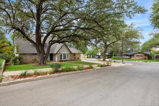 view of front of property featuring a front lawn and stone siding