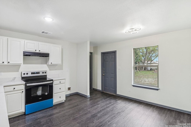 kitchen with under cabinet range hood, stainless steel electric range, dark wood-type flooring, visible vents, and white cabinetry