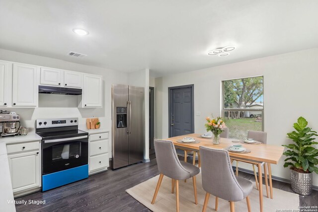 kitchen featuring stainless steel appliances, under cabinet range hood, light countertops, dark wood-style flooring, and visible vents