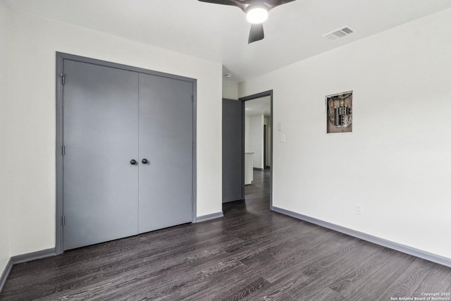 unfurnished bedroom featuring visible vents, ceiling fan, a closet, baseboards, and dark wood-type flooring