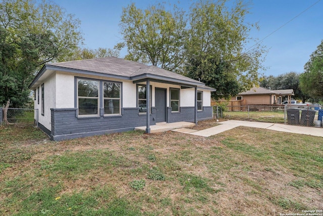 bungalow with a front yard, a patio area, stucco siding, and fence