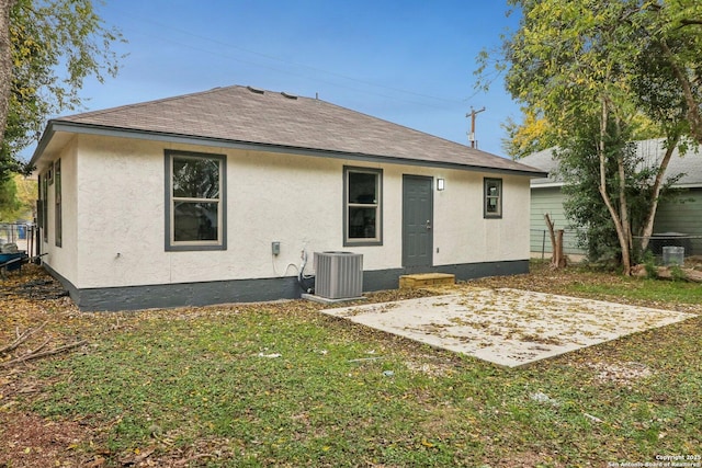 back of property with a patio area, a yard, stucco siding, and roof with shingles