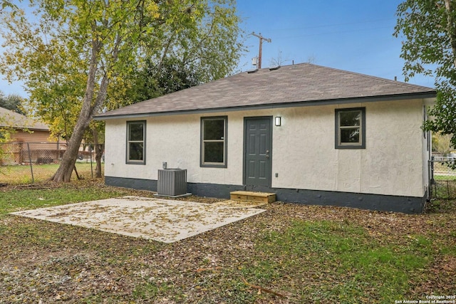 back of house featuring a patio, cooling unit, roof with shingles, stucco siding, and fence