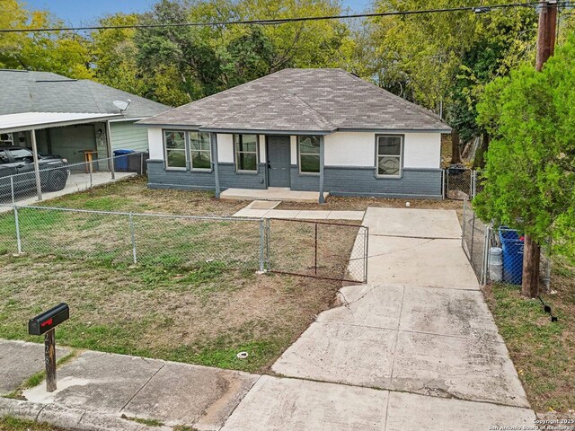 ranch-style home featuring a shingled roof, fence private yard, covered porch, a gate, and concrete driveway