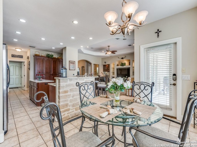 dining room featuring light tile patterned floors, recessed lighting, ceiling fan with notable chandelier, and arched walkways