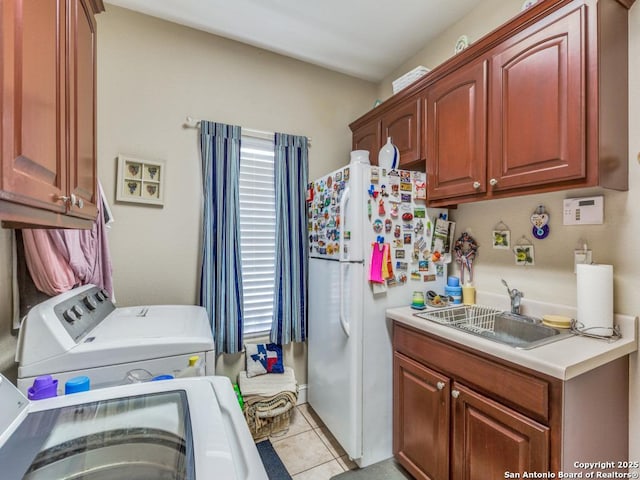 laundry area featuring light tile patterned floors, washer and dryer, a sink, and cabinet space